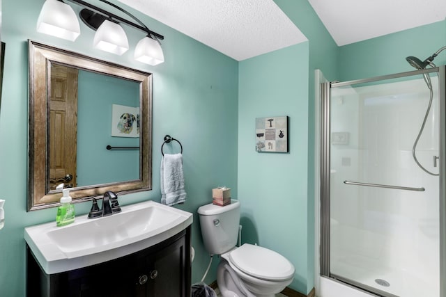 full bathroom featuring a textured ceiling, a stall shower, vanity, and toilet