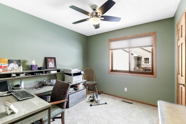 office space with a textured ceiling, carpet floors, a ceiling fan, and baseboards