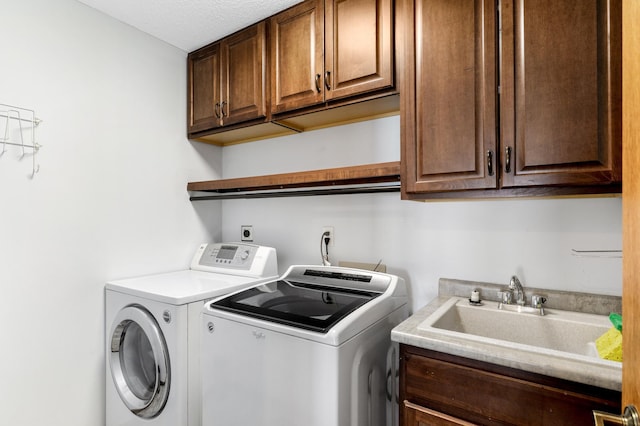 laundry area with cabinet space, a sink, and washer and clothes dryer