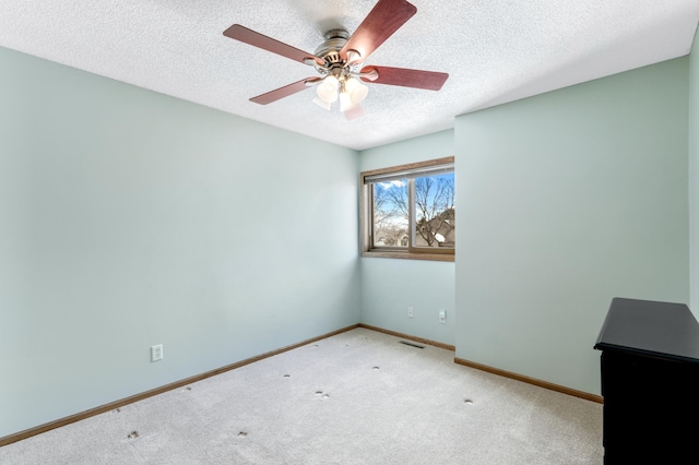 unfurnished room featuring visible vents, a textured ceiling, baseboards, and carpet flooring