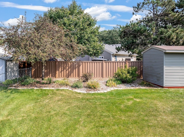 view of yard featuring an outbuilding, a fenced backyard, and a shed