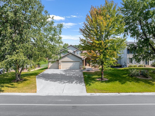 view of front of property featuring a garage, concrete driveway, and a front lawn