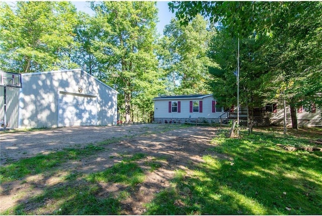 exterior space featuring an outbuilding, dirt driveway, and a garage