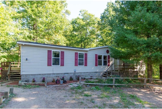 manufactured / mobile home with fence, a deck, and stairs