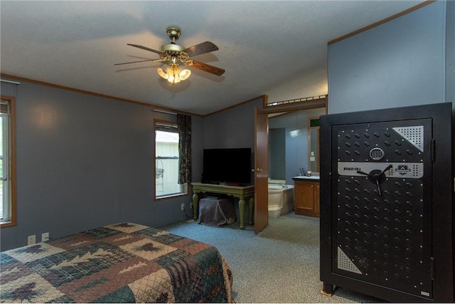 bedroom with crown molding, light colored carpet, vaulted ceiling, and ensuite bathroom