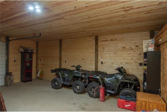 garage featuring wood ceiling and wooden walls