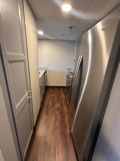 kitchen with a drop ceiling, stainless steel appliances, dark wood-style flooring, and light countertops