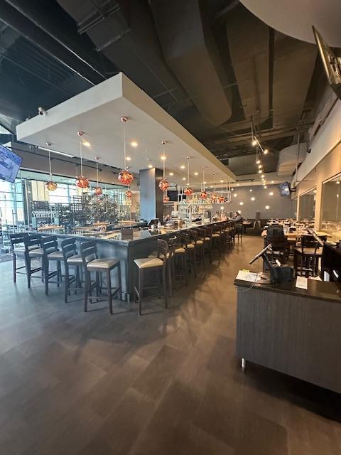 bar featuring decorative light fixtures and wood finished floors