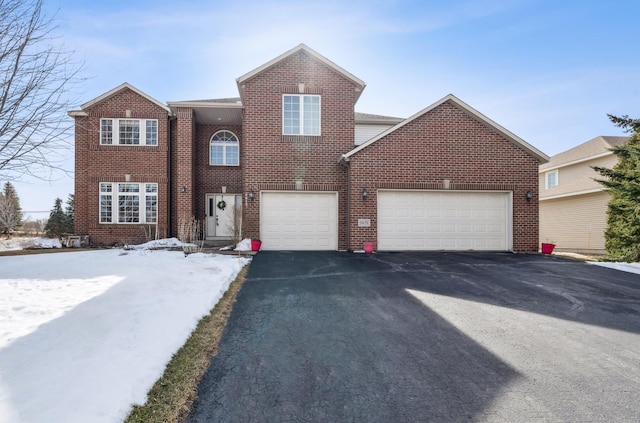 traditional home featuring aphalt driveway and brick siding