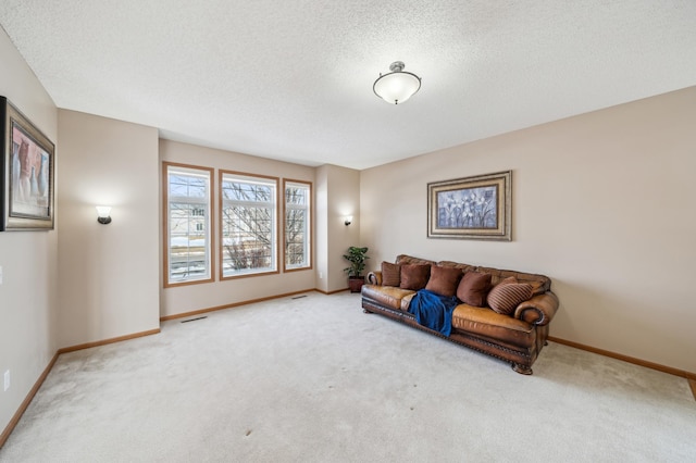 living area featuring carpet flooring, a textured ceiling, and baseboards