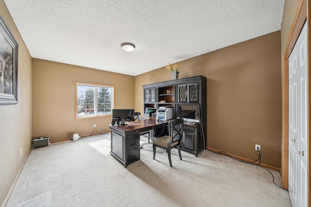 office area featuring baseboards, a textured ceiling, and carpet flooring