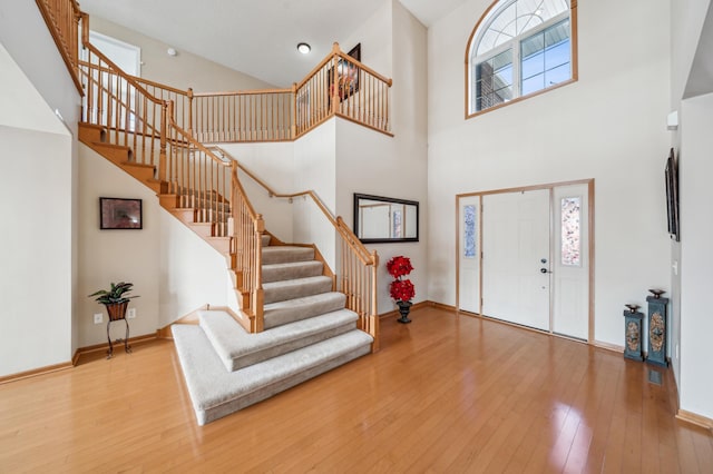 entrance foyer with stairway, baseboards, and wood-type flooring