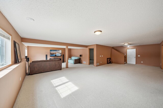 interior space with stairs, carpet floors, and a textured ceiling