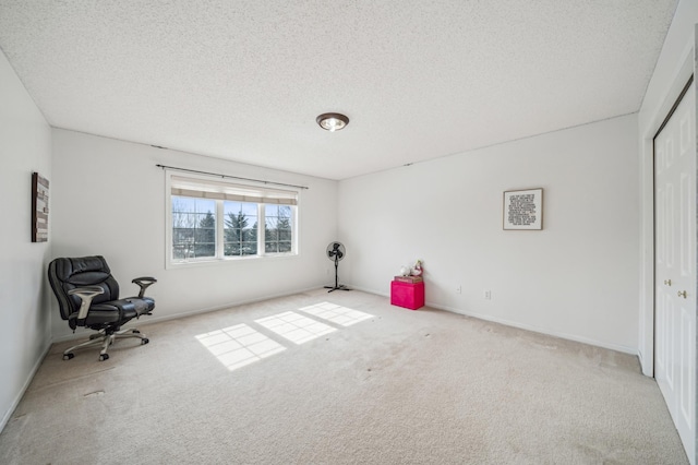 interior space with baseboards, a textured ceiling, and carpet