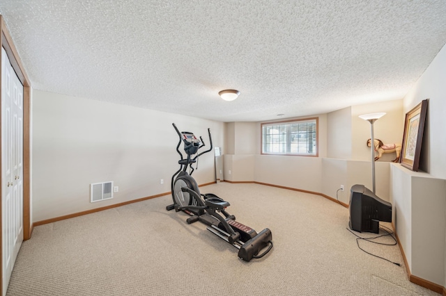 workout room featuring baseboards, visible vents, carpet floors, and a textured ceiling