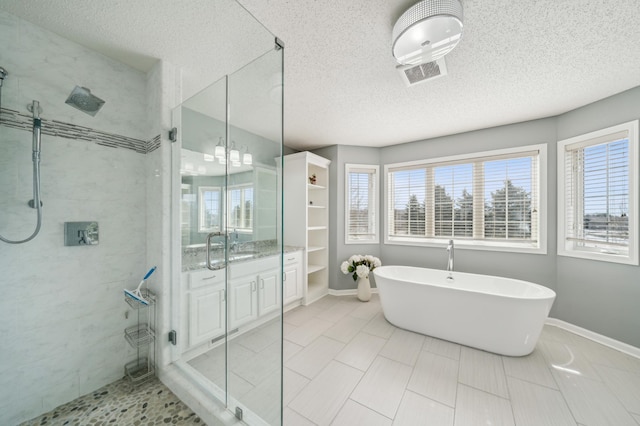 bathroom featuring a freestanding tub, visible vents, a stall shower, and baseboards