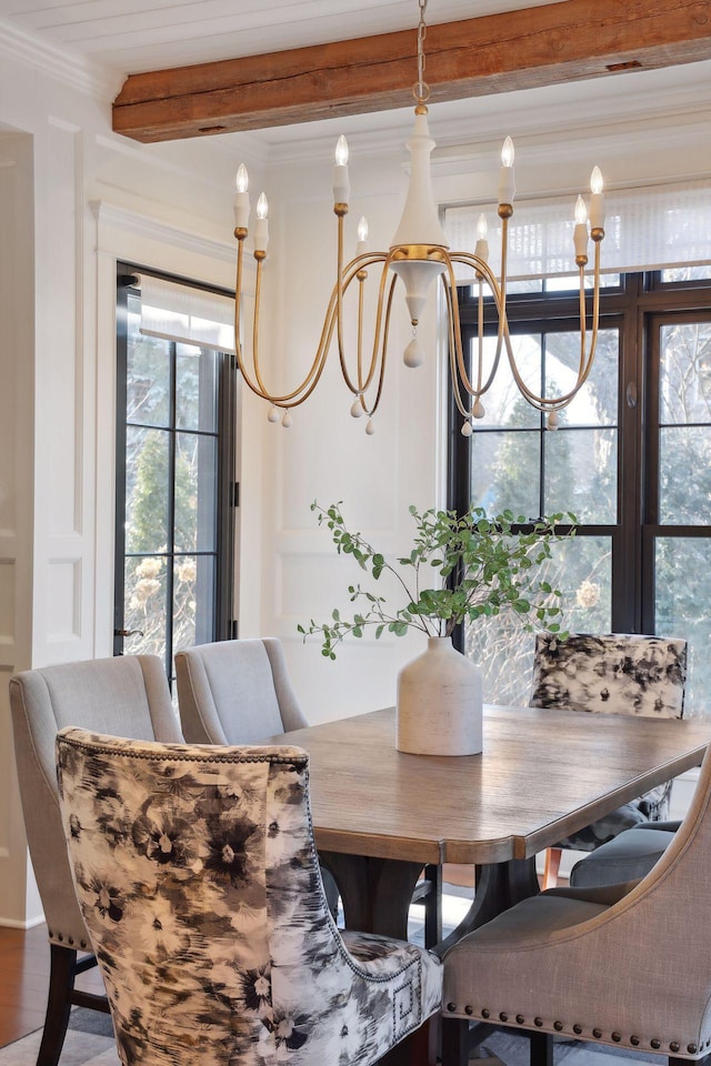 dining space featuring a notable chandelier, beamed ceiling, crown molding, and wood finished floors