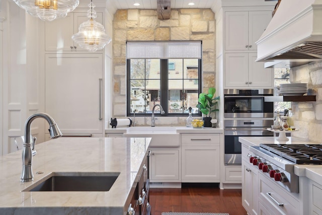 kitchen featuring a sink, tasteful backsplash, appliances with stainless steel finishes, custom exhaust hood, and dark wood-style flooring