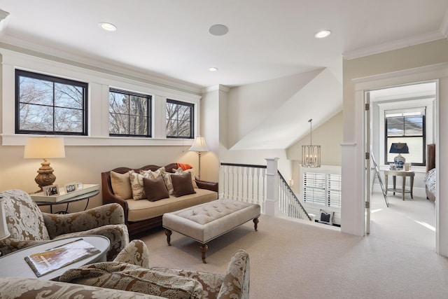 living area with crown molding, a healthy amount of sunlight, carpet floors, and a chandelier