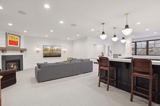 interior space with a glass covered fireplace, recessed lighting, and light colored carpet