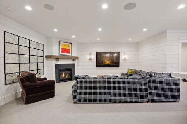 living area featuring a glass covered fireplace, carpet flooring, and recessed lighting