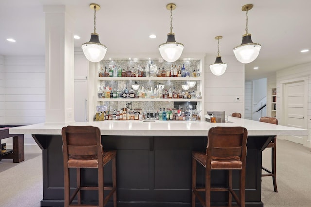 bar with hanging light fixtures, recessed lighting, light carpet, and a bar