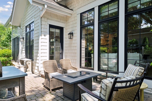 view of patio with an outdoor living space with a fire pit