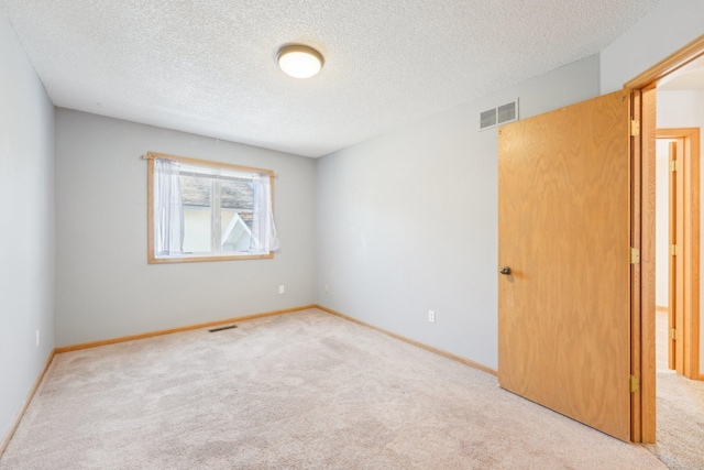 empty room featuring visible vents, baseboards, and carpet