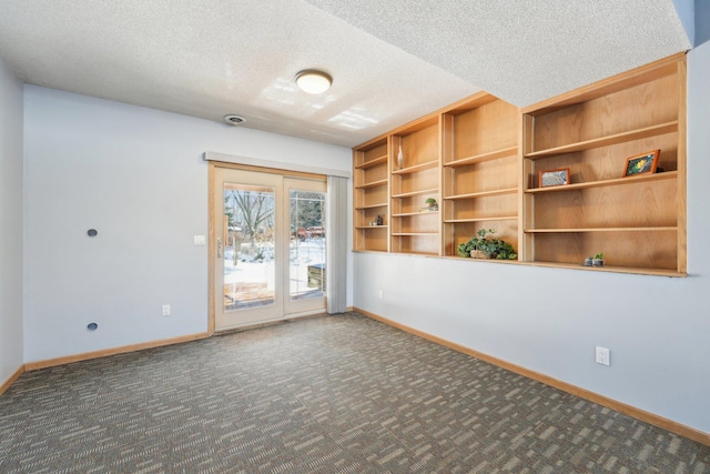 empty room with baseboards, carpet floors, and a textured ceiling