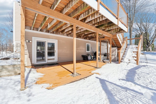 snow covered house featuring fence