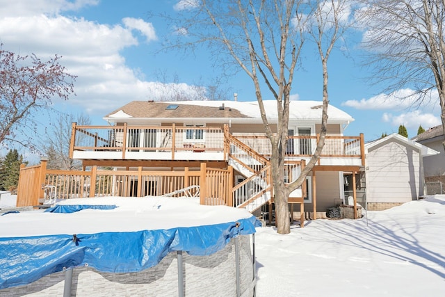 snow covered property featuring stairway and a deck