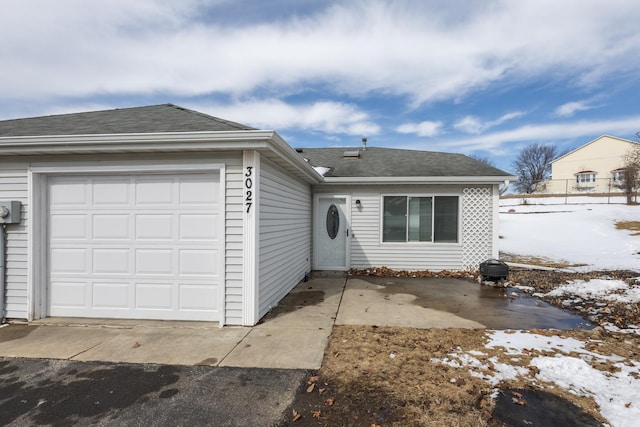 view of front facade with an attached garage and roof with shingles