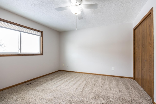 unfurnished bedroom featuring carpet, visible vents, baseboards, a closet, and a textured ceiling