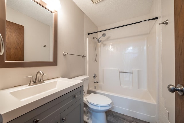 full bath featuring vanity, wood finished floors,  shower combination, a textured ceiling, and toilet