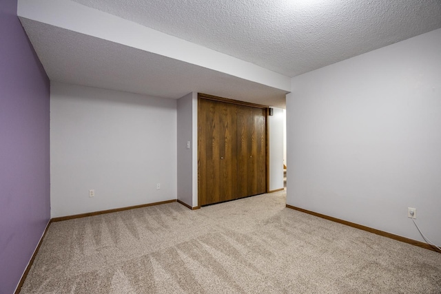 interior space with carpet, baseboards, a closet, and a textured ceiling