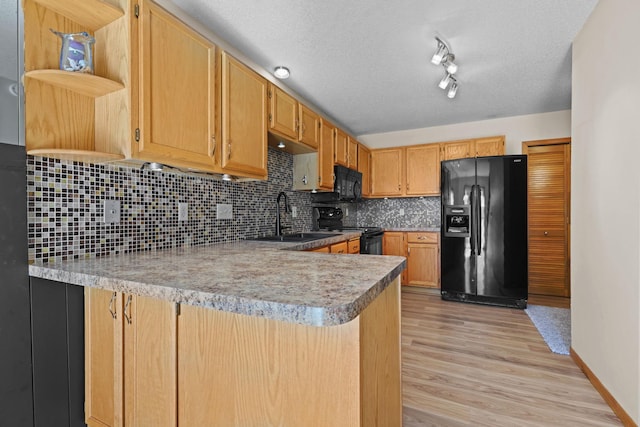 kitchen with black appliances, open shelves, a sink, light wood-style floors, and a peninsula