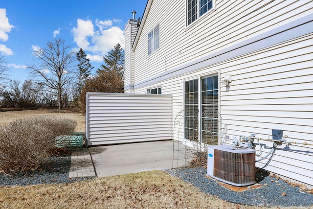 view of side of home featuring a patio area and central AC