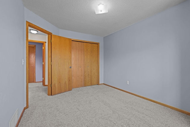 unfurnished bedroom featuring carpet flooring, baseboards, visible vents, and a closet