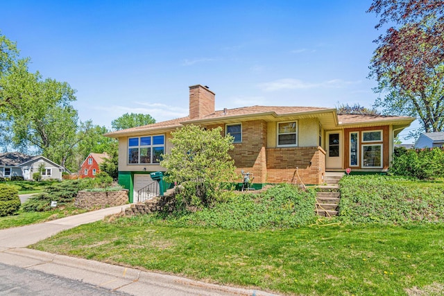 1938 Sheridan Ave, Saint Paul, MN 55116 - view of front of property featuring a garage, a chimney, brick siding, concrete driveway, and a front yard