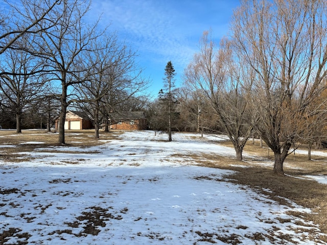 yard covered in snow featuring an outdoor structure and a garage