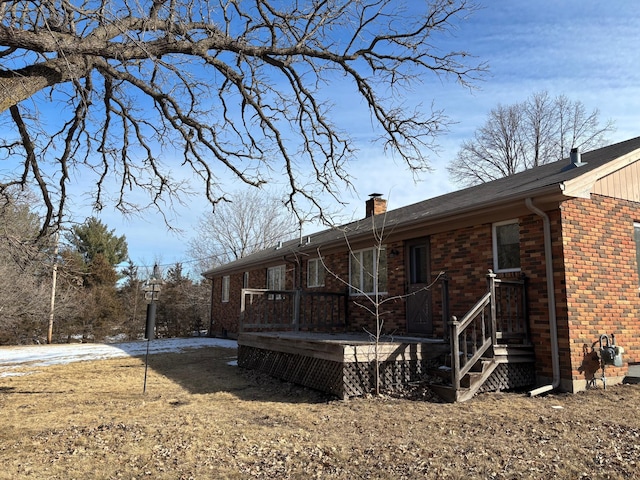 back of property with brick siding and a chimney