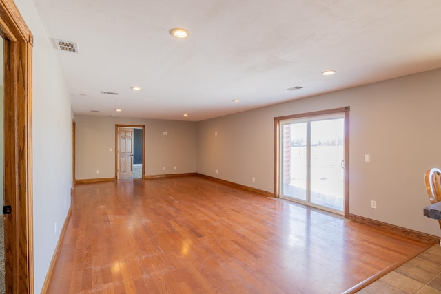 unfurnished room with visible vents, light wood-type flooring, and baseboards