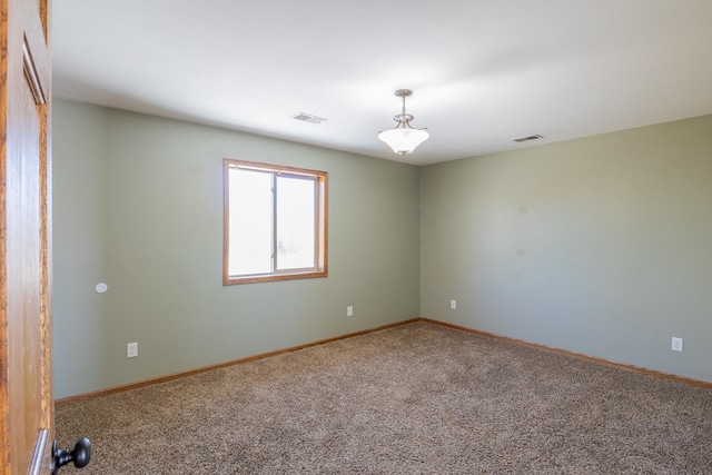 empty room with visible vents, carpet flooring, and baseboards