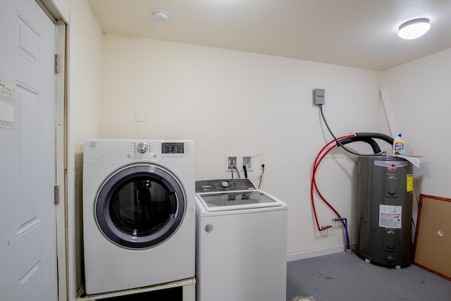 washroom with washer and dryer, laundry area, baseboards, and water heater