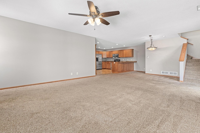 unfurnished living room featuring visible vents, recessed lighting, stairway, baseboards, and light colored carpet