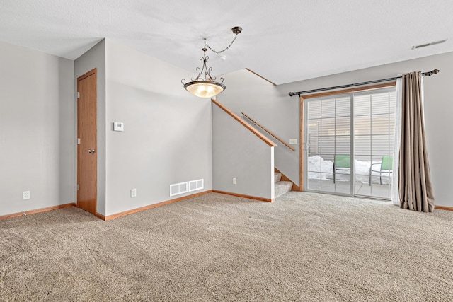 spare room featuring stairs, baseboards, visible vents, and carpet floors