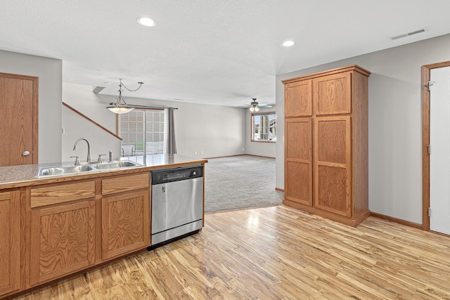 kitchen with brown cabinetry, visible vents, light wood-style flooring, a sink, and dishwasher