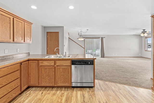 kitchen with a sink, open floor plan, a peninsula, light colored carpet, and dishwasher