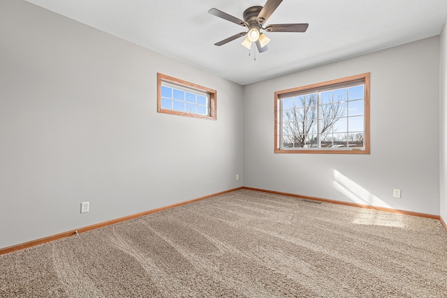 spare room with visible vents, plenty of natural light, baseboards, and carpet flooring