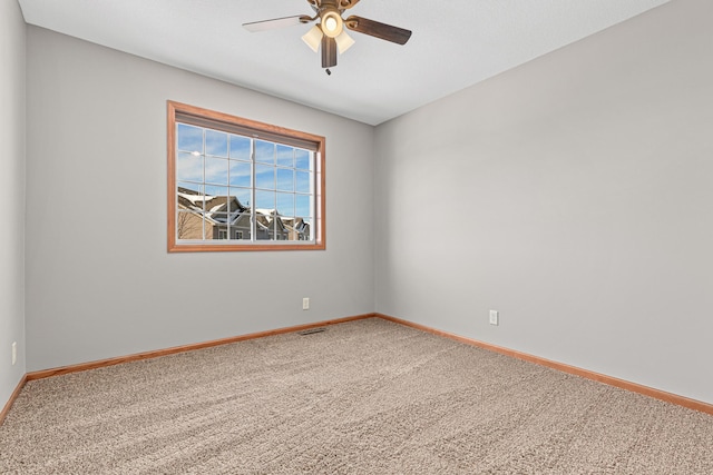 empty room with visible vents, baseboards, a ceiling fan, and carpet floors